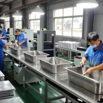 Stainless steel basin factory interior showing skilled workers assembling basins with precision.